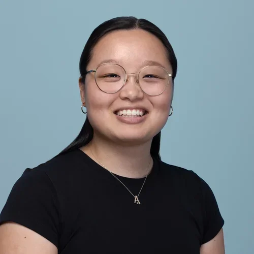 audrey luo wearing a black short sleeve shirt on a light bluish gray background