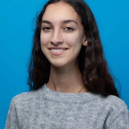 marie tafese wearing a gray sweater on a bright blue background