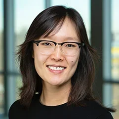 andrea oh wearing glasses and a black shirt