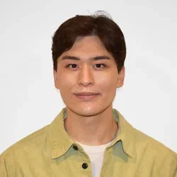 joshua genender in a yellow button up shirt against a white background