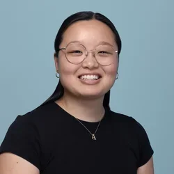 audrey luo wearing a black short sleeve shirt on a light bluish gray background