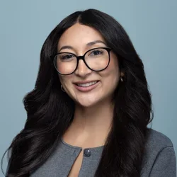 ashley teraishi wearing glasses on a light bluish gray background